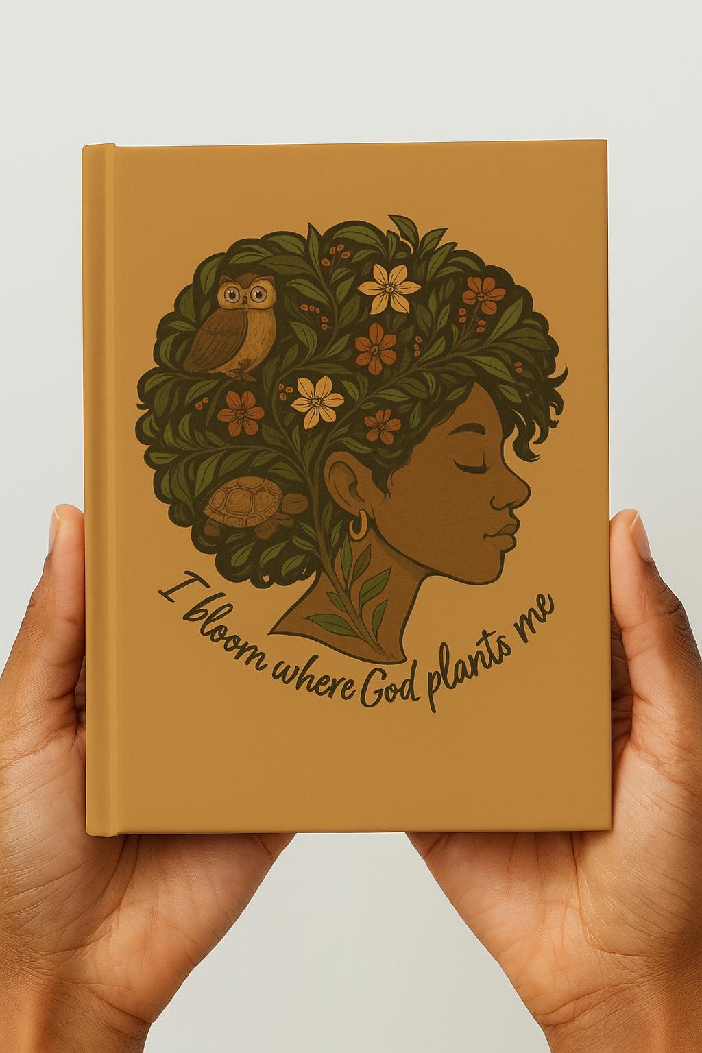 Christian affirmation journal held in hands, tan hardcover with Afrocentric Black woman illustration, floral hair, owl, turtle, and words I bloom where God plants me.